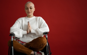 Mindful woman meditating with closed eyes in wheelchair